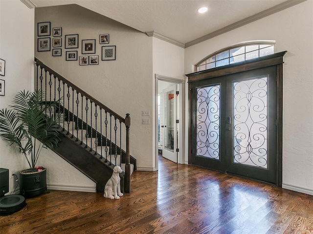 entrance foyer featuring dark hardwood / wood-style flooring, crown molding, french doors, and vaulted ceiling