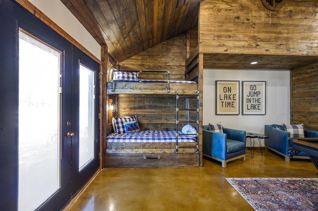 unfurnished bedroom with french doors, high vaulted ceiling, concrete flooring, wooden walls, and wood ceiling