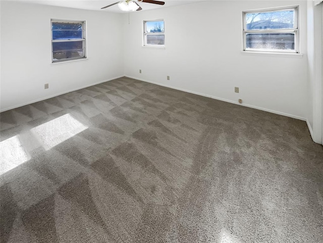 carpeted spare room with ceiling fan and plenty of natural light