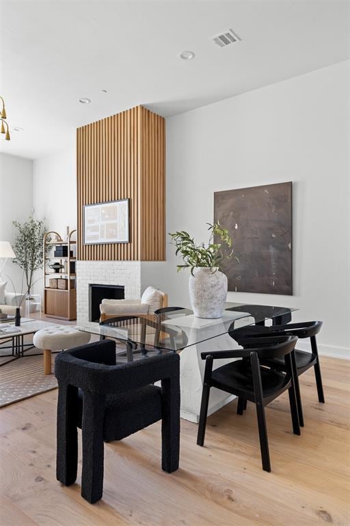 dining area featuring a fireplace and light hardwood / wood-style flooring