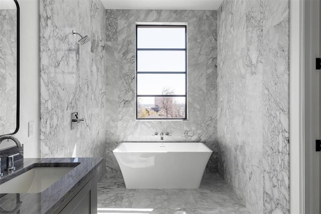 bathroom with vanity, a tub to relax in, and tile walls