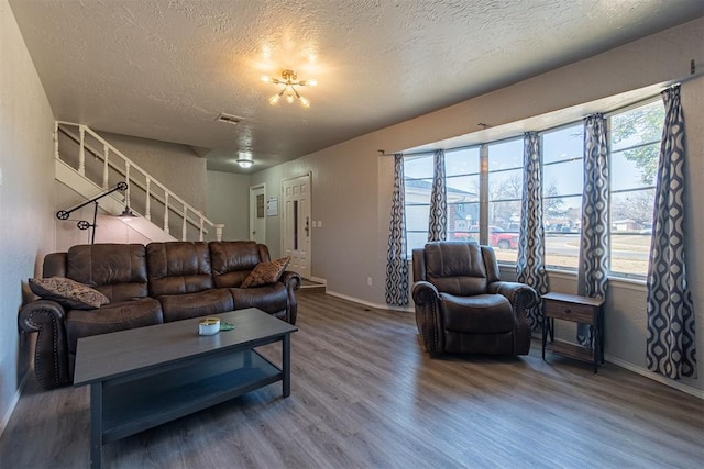 living room with a textured ceiling, hardwood / wood-style flooring, and a wealth of natural light