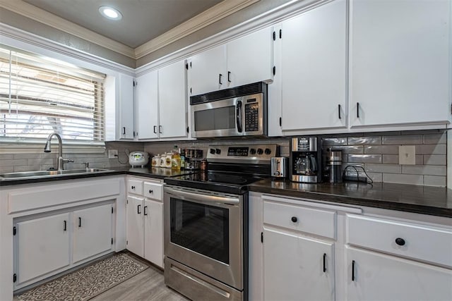 kitchen with sink, white cabinets, light hardwood / wood-style floors, and appliances with stainless steel finishes