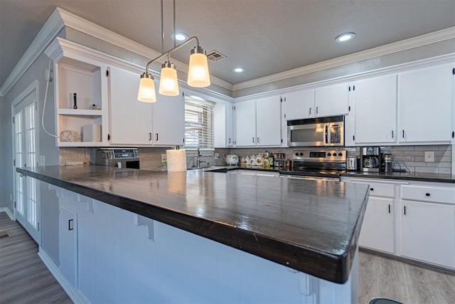 kitchen with white cabinetry, stainless steel appliances, tasteful backsplash, pendant lighting, and light wood-type flooring