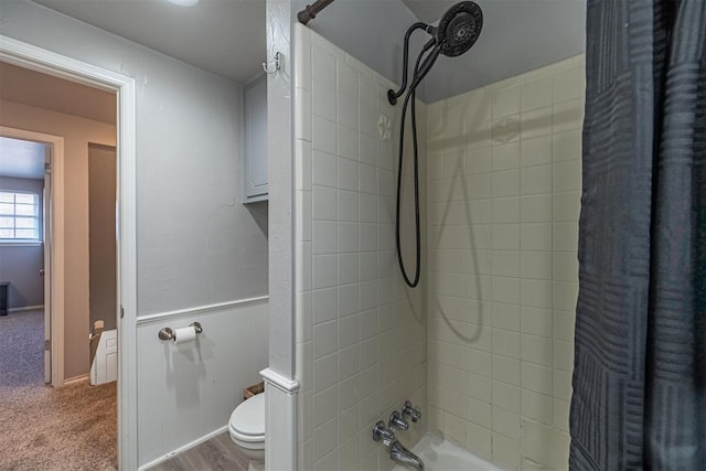 bathroom with tiled shower / bath combo and toilet