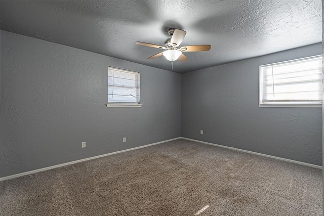 carpeted spare room with ceiling fan, a healthy amount of sunlight, and a textured ceiling