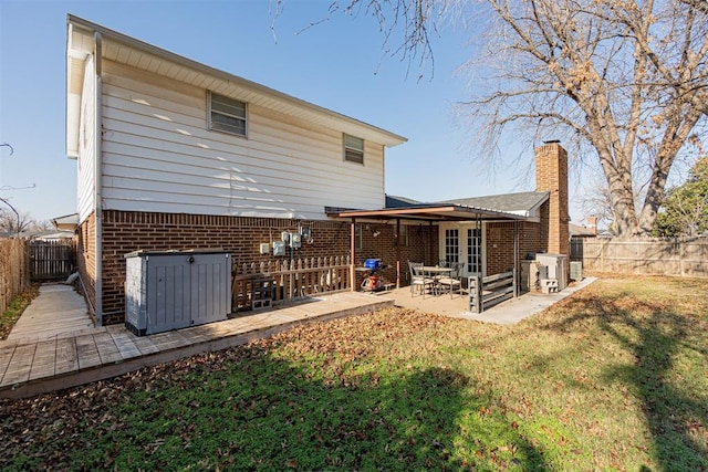 rear view of house with a patio and a lawn