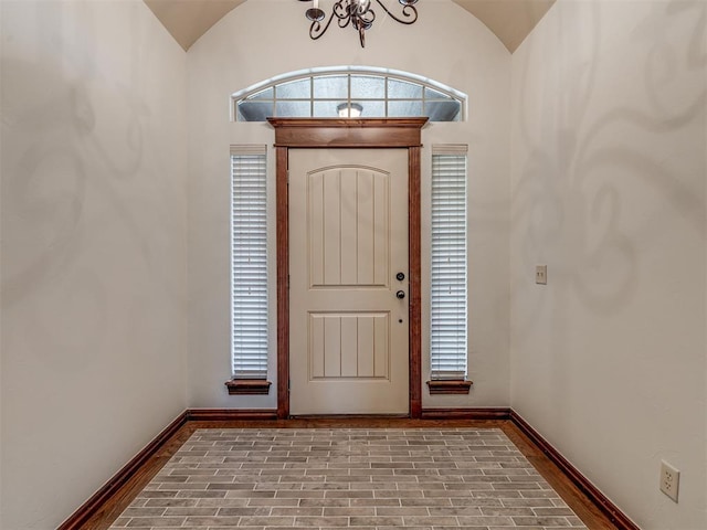 entrance foyer featuring lofted ceiling and an inviting chandelier