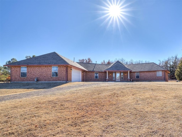 ranch-style house with a garage and a front lawn