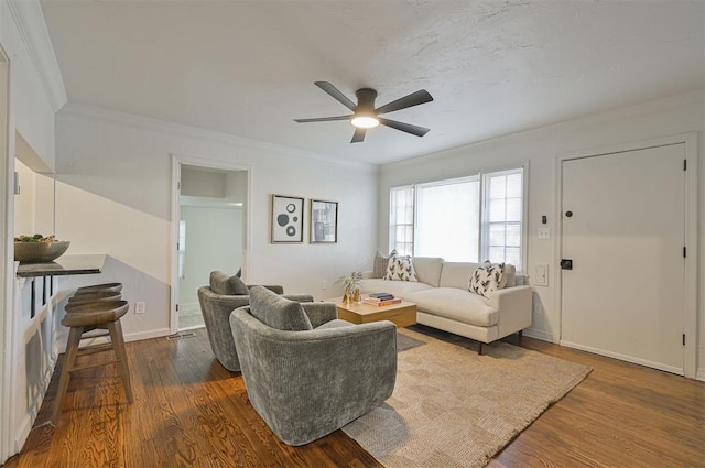 living room with ceiling fan, dark wood-type flooring, and ornamental molding