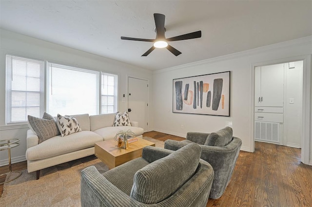 living room with dark hardwood / wood-style flooring, ceiling fan, and ornamental molding