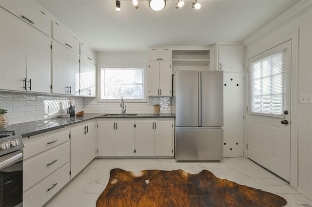 kitchen with white cabinets, decorative backsplash, sink, and stainless steel appliances