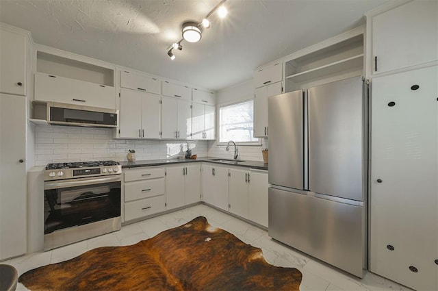 kitchen with white cabinets, sink, stainless steel appliances, and tasteful backsplash