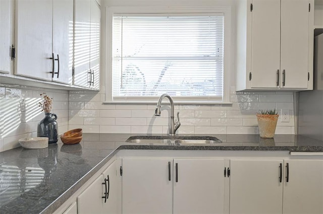 kitchen with white cabinets, tasteful backsplash, and sink