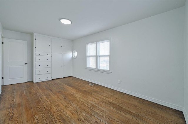 unfurnished bedroom with a closet and hardwood / wood-style floors