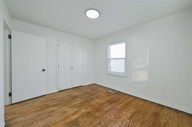 unfurnished bedroom featuring a closet and light hardwood / wood-style floors