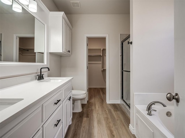full bathroom with toilet, vanity, wood-type flooring, and shower with separate bathtub