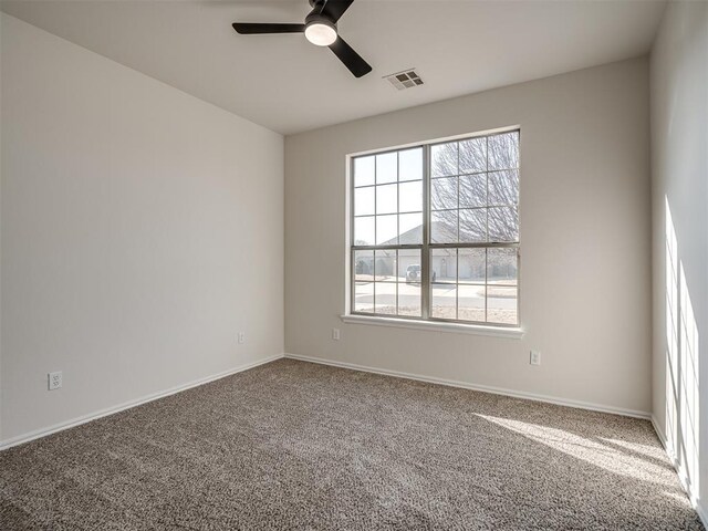 carpeted spare room featuring ceiling fan