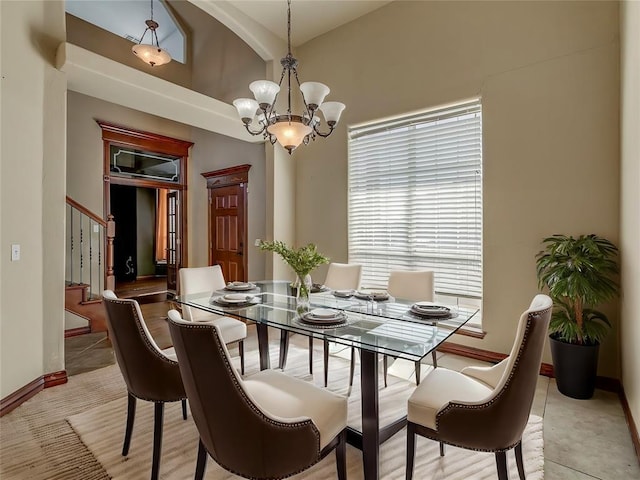 dining space with high vaulted ceiling and an inviting chandelier