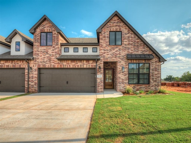 view of front of house with a garage and a front lawn