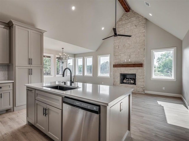 kitchen with sink, beam ceiling, dishwasher, gray cabinets, and an island with sink