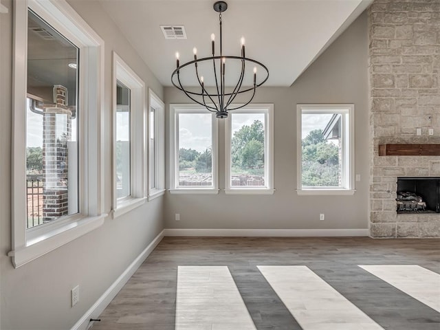 interior space with vaulted ceiling, a fireplace, and a chandelier