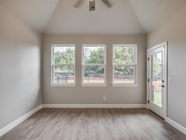 empty room with ceiling fan, light hardwood / wood-style floors, and vaulted ceiling