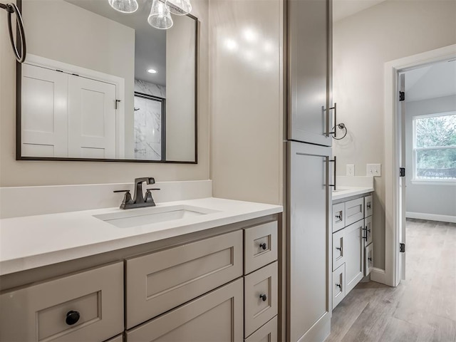 bathroom with hardwood / wood-style floors, vanity, and walk in shower