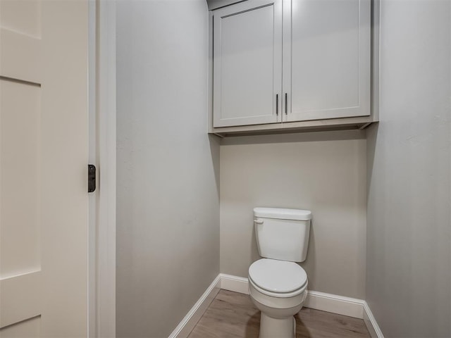 bathroom with hardwood / wood-style flooring and toilet