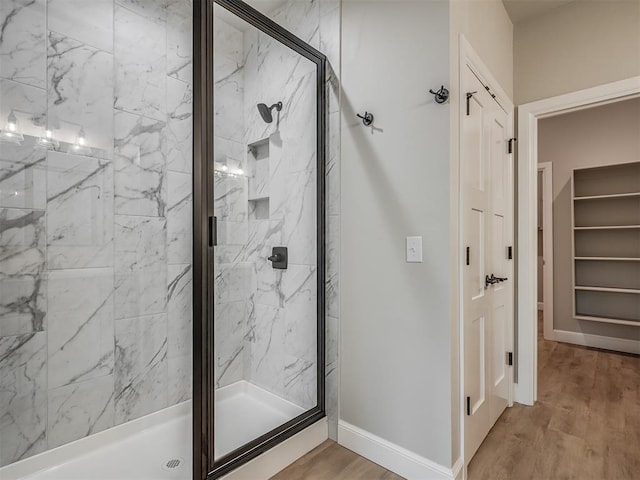 bathroom featuring wood-type flooring and a shower with door