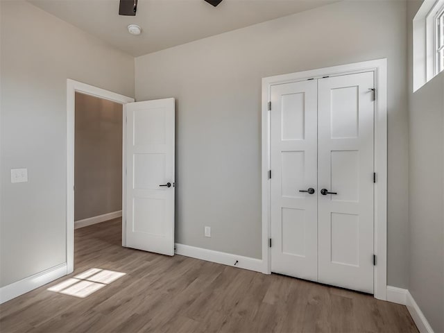 unfurnished bedroom featuring ceiling fan, a closet, and light hardwood / wood-style floors