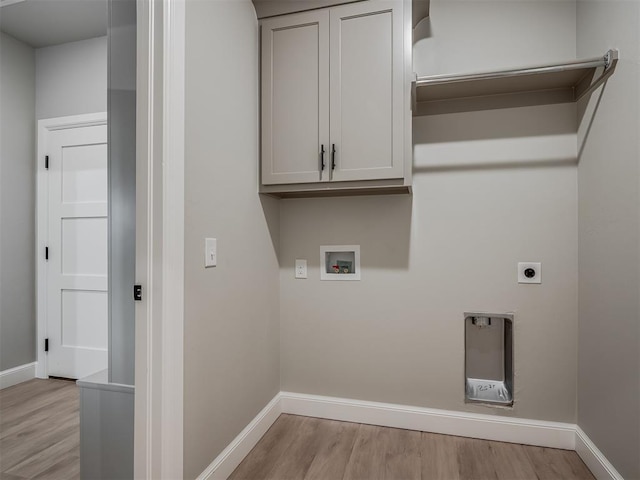 clothes washing area with hookup for an electric dryer, cabinets, light wood-type flooring, and hookup for a washing machine