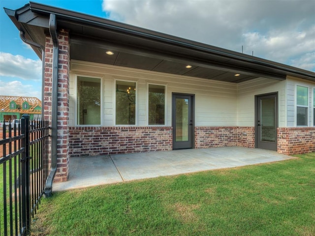 back of house featuring a lawn and a patio