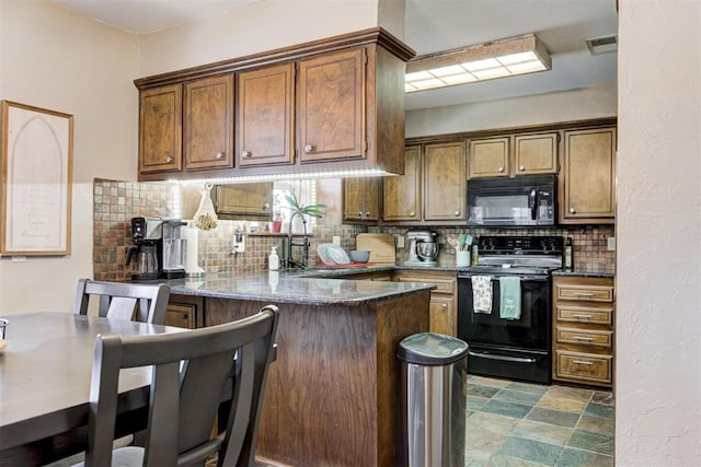 kitchen featuring sink, decorative backsplash, black appliances, and kitchen peninsula