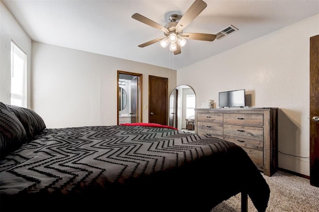 carpeted bedroom featuring ensuite bath and ceiling fan