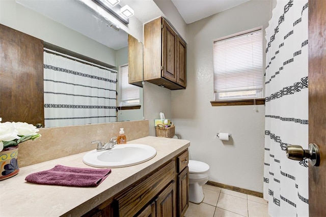 bathroom featuring toilet, vanity, tile patterned floors, and plenty of natural light