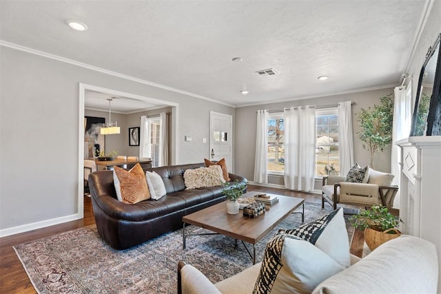 living room with crown molding, a chandelier, and dark hardwood / wood-style floors