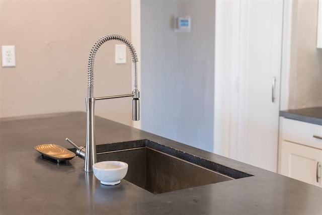 interior details featuring white cabinetry and sink