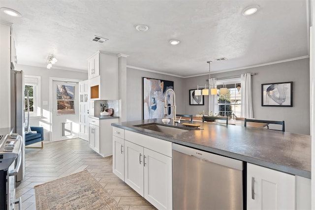 kitchen with stainless steel dishwasher, white cabinetry, and light parquet floors