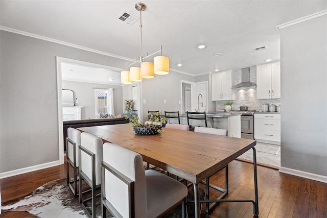 dining room with dark wood-type flooring and ornamental molding