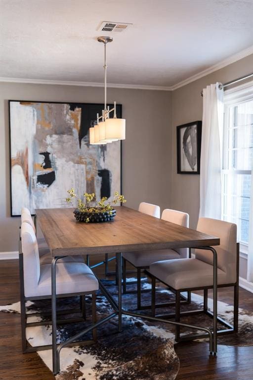 dining space featuring dark hardwood / wood-style flooring and crown molding