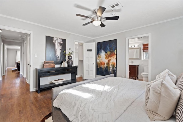 bedroom with dark hardwood / wood-style flooring, ensuite bathroom, ceiling fan, and ornamental molding