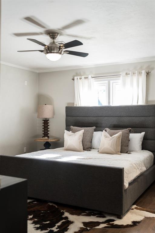 bedroom with ceiling fan, crown molding, and hardwood / wood-style flooring