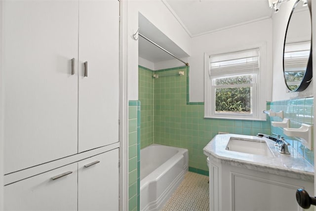 bathroom with tile patterned flooring, tub / shower combination, crown molding, vanity, and tile walls