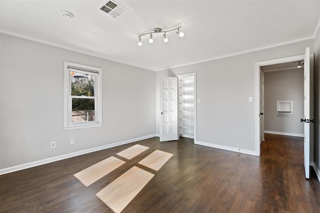 unfurnished bedroom with dark hardwood / wood-style flooring, crown molding, and a closet