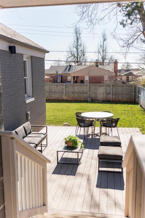 wooden terrace with an outdoor hangout area and a yard