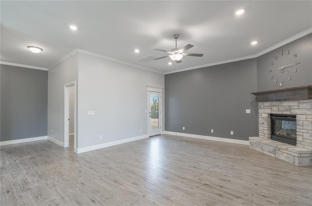 unfurnished living room with ornamental molding, a stone fireplace, ceiling fan, and light hardwood / wood-style floors