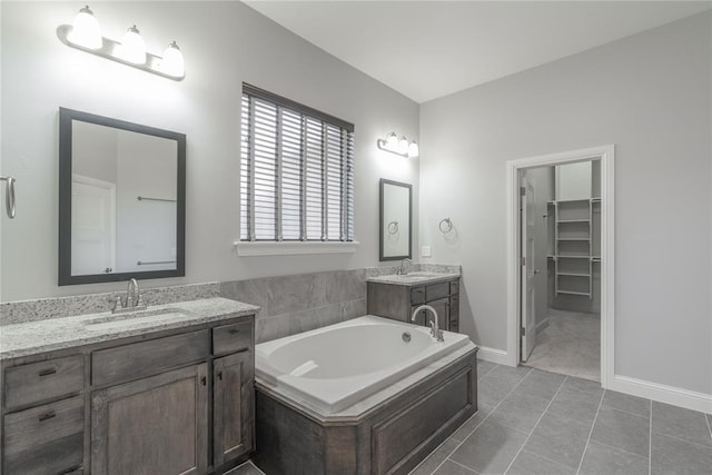 bathroom featuring vanity, tile patterned flooring, and a washtub