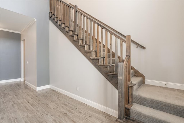 staircase featuring crown molding and wood-type flooring