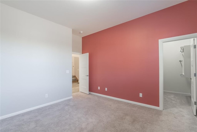 interior space with a walk in closet and light colored carpet